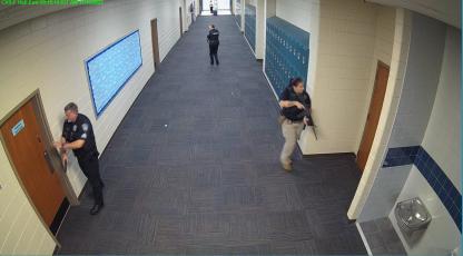 Still shots from security cameras inside Camden County High School show law enforcement officials searching the school for a shooter Nov. 30. Reports of a shooting at the school were a hoax.