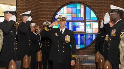 Cmdr. James Kepper IV, incoming commanding officer of the Ohio-class ballistic-missile submarine USS West Virginia (SSBN 736) Blue Crew, salutes the side boys during a change of command ceremony at the chapel onboard Naval Submarine Base Kings Bay.