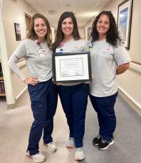 Southeast Georgia Health System’s lactation intern Natasha Jovin, and lactation consultants Jennifer Bergman and Jessica Albright hold up the hospital’s award for excellence in lactation care.